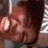 A pixelated close-up of a person's face with dark hair and light skin, partially obscured by a blurred background.
