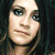 A woman with long dark hair appears in three distinct poses: a direct gaze, hands clasped under the chin, and looking upward while wearing a red top.