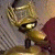 Animated character with golden metallic texture, large eyes, and horn-like ears, transitioning from side profile to front-facing view against dark background.