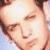 Pixelated close-up of a person's face with closed eyes, light skin tone, and brown hair against a light blue background.