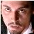 Pixelated close-up of a person's face with visible eyes, nose, mouth, and partial dark hair against a light background.