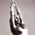 A grayscale pixelated image of a hand holding a small object against a plain background.
