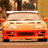 A static image of a light orange car with a white roof rack, positioned on a wooden shelf against a blurred background.