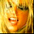Pixelated close-up of a person's face with warm yellow-orange tones and visible dithering, appearing as a low-resolution static icon.