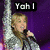 A person with blonde hair holds a microphone, wearing a silver sequined jacket against a purple background. Text overlays read "Yah I", "Really Am", and "ROCKSTAR!" across different frames.