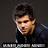 Pixelated static image of a person with dark hair and a dark jacket, facing slightly left against a dark background with a horizontal bar at the bottom.