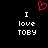 A black background displays two identical white text blocks reading "I love TOBY" with a red pixelated heart above them.