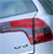 Pixelated red and blue vehicle with visible taillights and a curved roofline against a light blue background.