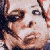 Pixelated close-up of a person's face with dark hair, visible eye, nose, and mouth, rendered in brown, white, and black tones.