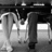 Black-and-white photo of two people holding hands under a table with red pixelated text on white background.