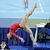 Four distinct gymnastics scenes: a male in red leotard on balance beam, female in pink on high bar, female in white with number 15 on black background, and text 'GYMNASTICS IS LIFE' with heart symbol.