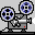 Two pixel-art film projectors on gray platforms, each with dual reels showing blue and black patterns, red indicator lights, and white light beams.