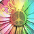 A vibrant, pixelated flower with pink, yellow, and green petals radiating from a brown center, displayed in a