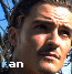 A pixelated image of a man's face with the word 'fan' in blue text at bottom left, set against a tree and sky background.
