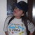 A child wearing a dark blue cap and white shirt with colorful text stands against a blurred background, appearing in two slightly different poses.
