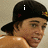 A person wearing a black cap with yellow and red details, with text appearing sequentially above the cap in four