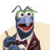 Pixelated character with green head, blue face, and red mouth wearing dark jacket over white shirt, holding small object.