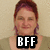 A static image of a person with short reddish-brown hair wearing a light green top and purple necklace, with a black rectangular overlay containing white text.