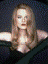 A woman with long brown hair in a black dress poses against a dark background, transitioning to a white backdrop while maintaining the same pose.