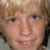 A pixelated close-up of a person's face with light brown hair, visible eyes, nose, and mouth against a blurred background.
