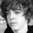 Black-and-white pixelated portrait of a person with curly hair next to light purple background with bold text reading "who does not love a gorgeous guy like RYAN?!?"