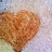 A heart-shaped icon with a textured brown surface, set against a light background with subtle color variations.