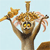 A pixelated cartoon monkey with brown fur, yellow eyes, and a black mouth holds a golden trophy above its head against a light blue background.