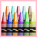 Colorful crayon-like shapes in various hues stand upright against a white background with pink border, their reflections visible below.