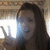 A pixelated image shows a person with long dark hair holding a glowing blue object near their face against a blurred background.