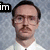 A static portrait of a man with glasses and a mustache in a white shirt against a gray background, overlaid with three distinct text blocks.