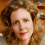 A pixelated image of a person with curly brown hair, light skin, and red lips in two side-by-side views showing slight facial expression differences.