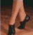 Animated sequence showing a person's legs and feet in three positions: walking, barefoot on wooden floor, and kicking with black shoes.