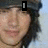 A person with long dark hair and a black cap appears in four , showing sequential changes to the face and text elements