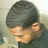 Pixelated close-up of a person with short dark hair, light skin tone, and closed eyes in profile view against blurred background.
