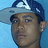 Pixelated close-up of a person wearing a blue and white cap with a white logo, set against a light blue background.