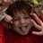 A pixelated image shows a person with dark hair and a red garment, hand near face, next to a red background with partial text.