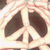 A pixelated static icon shows a white peace symbol with dark brown or black arms against a light beige background.