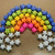 A pixelated rainbow arch spans the top of a brown background, with white cloud shapes below it on both sides.