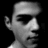 Pixelated grayscale profile of a person wearing a cap, facing right with a neutral expression against a black background.