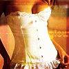 A person wearing a white lace-trimmed top with buttons, positioned against an orange-toned background.