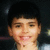 Pixelated close-up of a person with short dark hair, light skin, and visible facial features against a dark background.
