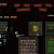 Static pixelated image showing a dark background with multiple rectangular elements including red, green, and brown shapes.