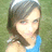 A pixelated image of a person with shoulder-length brown hair wearing a blue sleeveless top, standing against a green background.
