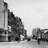 Black-and-white pixelated image showing a tall vertical structure with a flagpole and dark irregular shapes resembling buildings or trees against a light background.