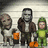 Three pixelated figures stand side-by-side: a bald man in white, a robot-like figure with dark clothing and orange accents, and a green-clad character with a helmet.
