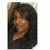 Pixelated static image of a figure with long dark hair against a dark background, wearing a light brown sleeveless top.