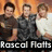 Three people pose together in a group photo with a gradient orange background, one person wearing a white shirt and two in dark shirts.