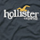 Pixelated text 'hollister' in white with a yellow curved accent above the letter 'i', set against dark gray background.