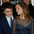 Pixelated image of two people in formal attire on a blue background with white text and emoticon.