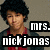 A pixelated image of a person with curly hair wearing a red shirt and dark jacket, with text overlays and a gray background.